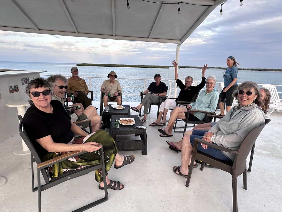 Snorkeling group smiling on a boat in Jardines de la Reina, Cuba, ready to explore coral reefs and marine life.